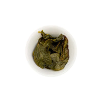 Ein ansprechendes Foto von den losen, aufgebrühten Blättern unseres Oolong Tees Midnight Monk in einer Tasse.