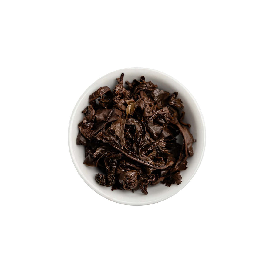 Ein ansprechendes Foto von den losen, aufgebrühten Blättern unseres GABA Oolong Tees Ruby Sky in einer Tasse.