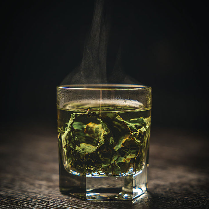 Ein ansprechendes Foto von einem Grünen Tee in einem Whiskeyglas