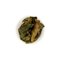 Ein ansprechendes Foto von den losen, aufgebrühten Blättern unseres Oolong Tees Sunbeam in einer Tasse.